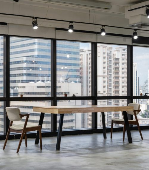 Empty wooden conference table with chairs in coworking space on downtown